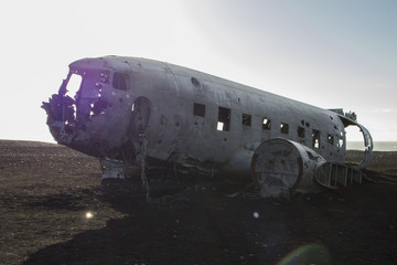 Carcass of airplane on the black beach