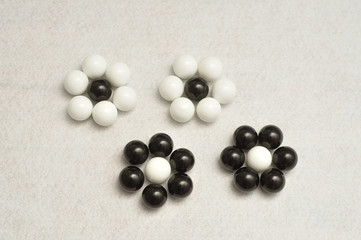 White and black balls packed in the shape of a flowers isolated on a white background