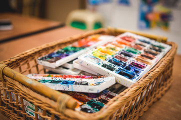 Old watercolor paints in basket