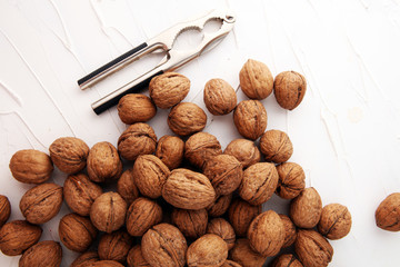 Walnut kernels and whole walnuts on table with a nutcracker