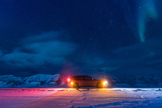 The polar arctic Northern lights aurora borealis sky star in Norway Svalbard in Longyearbyen city car the moon mountains