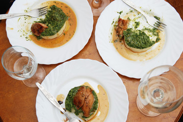 Dinner. Roast chicken breast with Spinach and Mashed Potatoes on Round Table with White Wine Glasess.