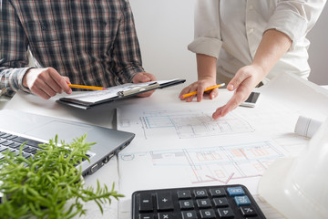 Architects working on blueprint, real estate project. Architect workplace - architectural project, blueprints, ruler, calculator, laptop and divider compass. Construction concept. Engineering tools.