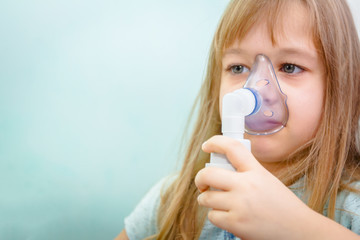 Portrait of sweet little girl using an inhaler