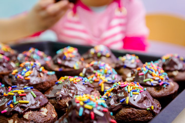 Fototapeta na wymiar Portrait of sweet little child eating cake, decorated muffins