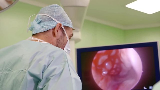 surgeon watching an image from endoscopic camera on a display of contemporary technological equipment