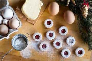 Dusting traditional Linzer Christmas cookies with sugar on a rolling board