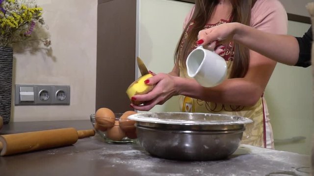 Slider shooting of two women in aprons that are cooked in the kitchen