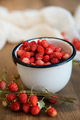 fresh wild strawberries in a Cup in the shape of a heart, symbol of love. Wooden background. The view from the top