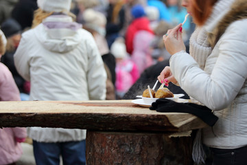 Dłonie kobiety w czasie jedzenia pieczonych ziemniaków w czasie pikniku. - obrazy, fototapety, plakaty