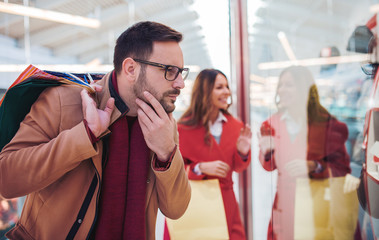 Shopping time. Young couple shopping together in shopping mall. Consumerism, love, dating, lifestyle concept