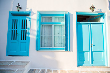 Traditional houses withe blue doors in the narrow streets of Mykonos, Greece.