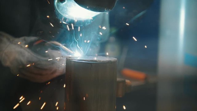 The welder welds metal parts