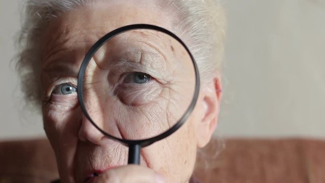old lady looking through a magnifying glass