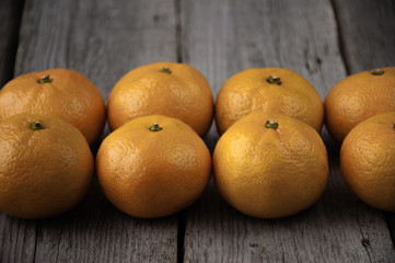 On a wooden background fresh tangerines in two rows