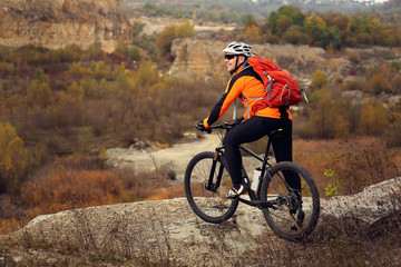 man in sportswear jumping high on mountain bicycle on background of landscape.