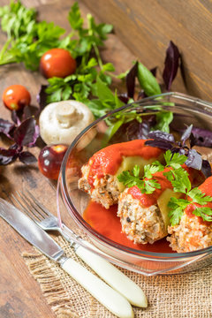 Yummy looking cooked stuffed pepper served in a transparent glass pot on a wooden table