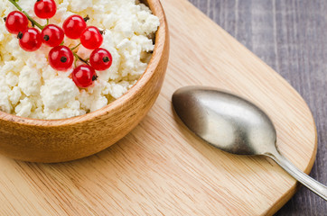 cottage cheese with red berries and mint in a wooden bowl/cottage cheese with red berries and mint in a wooden bowl. Top view
