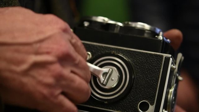 Mechanical rolling film inside vintage photo camera, human hand close up slow motion