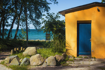 Gelbes Haus am Meer mit blauer Tür