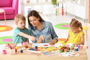 Fototapeta premium Happy family painting pictures at table indoors