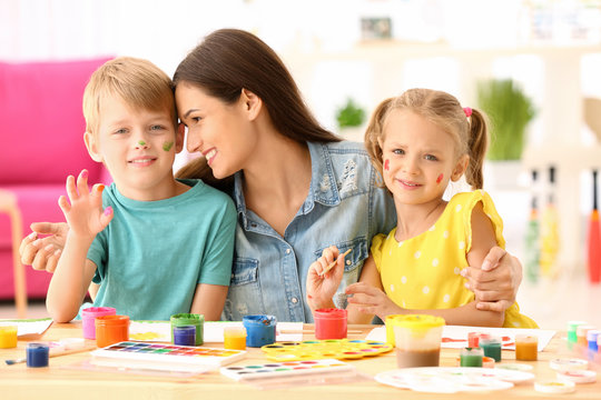 Happy family painting pictures at table indoors