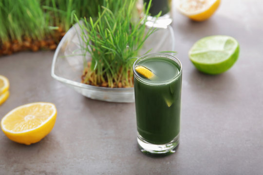 Shot of healthy juice and sprouted wheat grass on table
