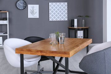 Modern office interior with wooden table and armchairs