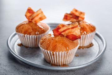 Plate with tasty bacon muffins on table