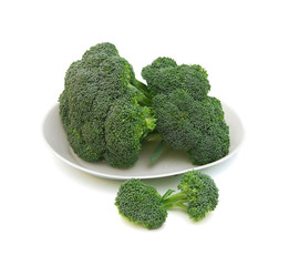 branches of cabbage of a broccoli in plate on a white background