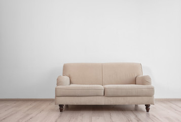 Stylish sofa on white wall background