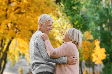 Cute elderly couple dancing in autumn park