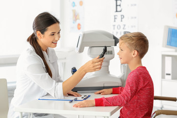 Ophthalmologist inspecting eye fundus of little child in clinic