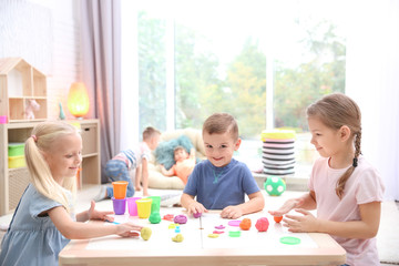 Fototapeta premium Little children engaged in playdough modeling at daycare