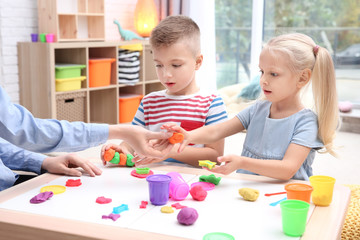 Naklejka premium Little children engaged in playdough modeling at daycare
