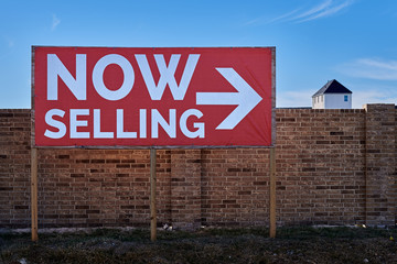 Fototapeta premium Now Selling Sign Posted in Front of a Up-and-Coming Neighborhood