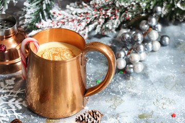 Obraz na płótnie Canvas Holiday Eggnog cocktail served in copper mug on xmas background, selective focus