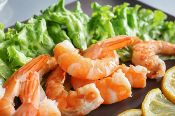 Delicious shrimps with lemon and lettuce, closeup