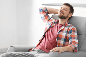 Fototapeta premium Handsome man relaxing in armchair at home