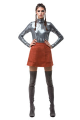 Obraz premium Young beautiful lady standing in light brown skirt and silver top with sequins and knee high boots on white background