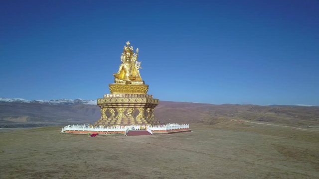 Big Buddha on the grass hill at Yarchen Gar Monastery in Garze Tibetan, Sichuan, China.