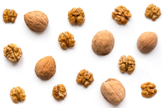 Creative Walnut Pattern. Nuts kernel with nutshell on white background. Top view.
