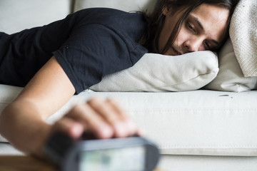 A sleepy Caucasian man turning an alarm off