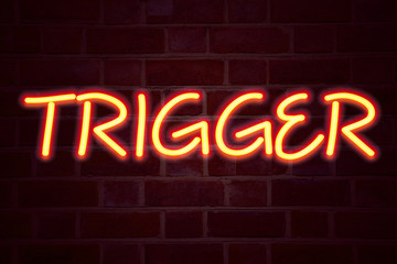 Fototapeta premium Trigger neon sign on brick wall background. Fluorescent Neon tube Sign on brickwork Business concept for Stir Spark Loose or Unleash Idea 3D rendered