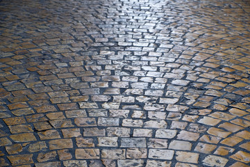 old cobblestone or cobble stone street road surface at night backlit background texture photo