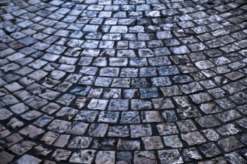old cobblestone or cobble stone street road surface at night backlit background texture photo