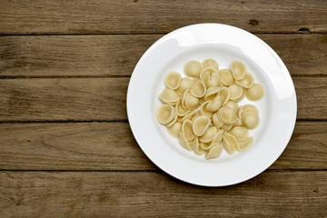 Pasta shell  in White Plate on wooden