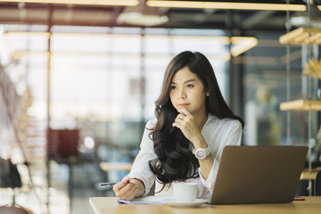 Young business woman using on the laptop while sitting at her working place.