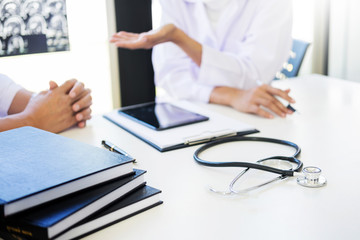 Professor Doctor discussion a method with patient treatment, with Mammogram film x-ray of patient 's head for brain, skull or eye injury and laptop computer on table