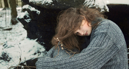 girl in the grey sweater in the winter forest